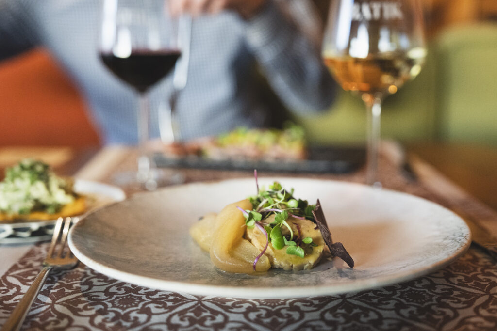 Plato gourmet con foie, peras caramelizadas y brotes frescos en el restaurante Batik de Málaga.